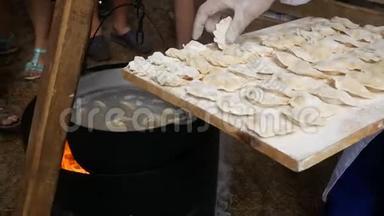 自制饺子的过程.. 生的自制饺子放在木板上.. 厨师包饺子，包饺子